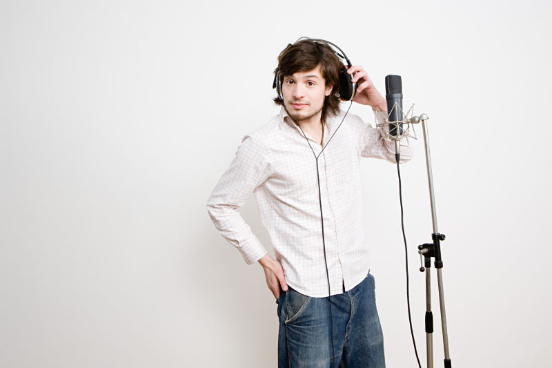 话筒前戴着耳机的年轻男人