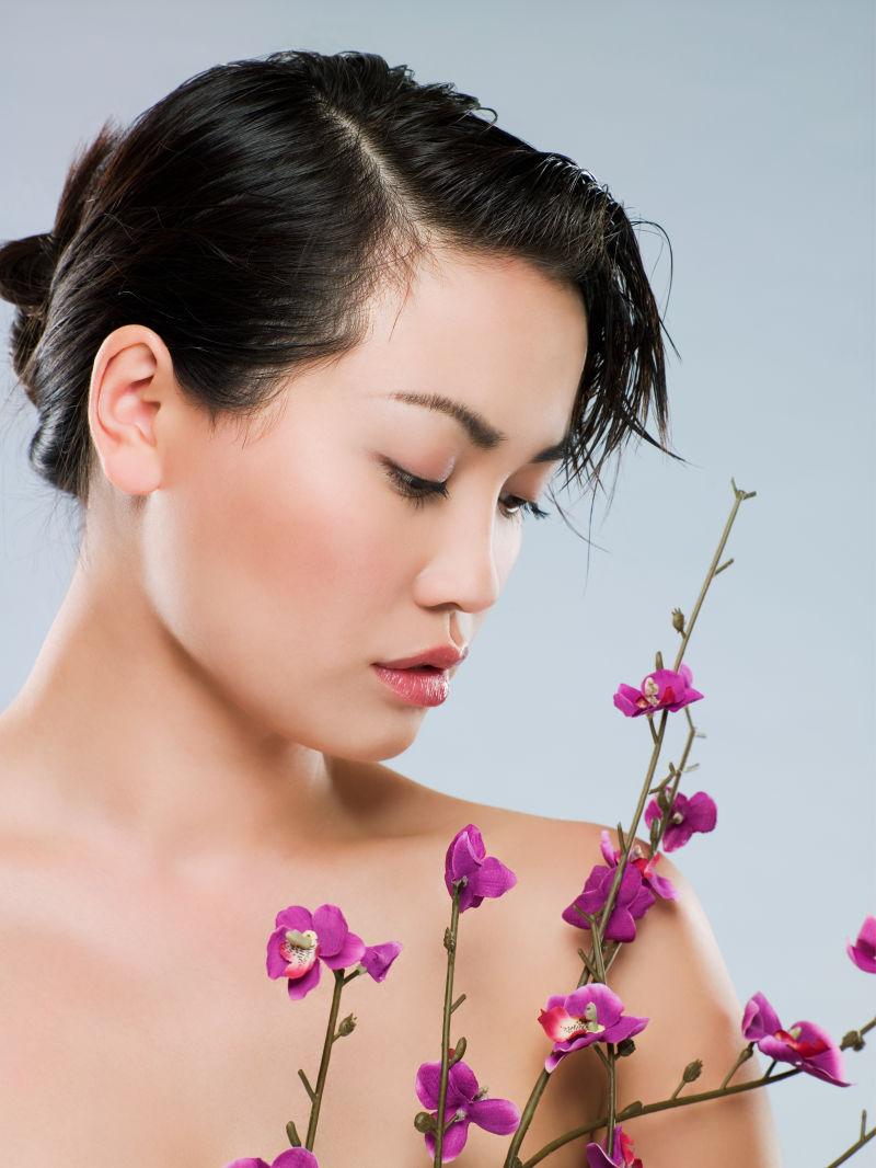 拿着紫色花卉的时尚美女