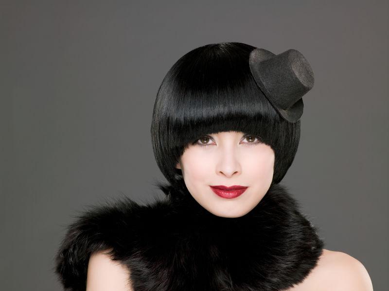 时尚的美女带着黑色的小帽子发饰