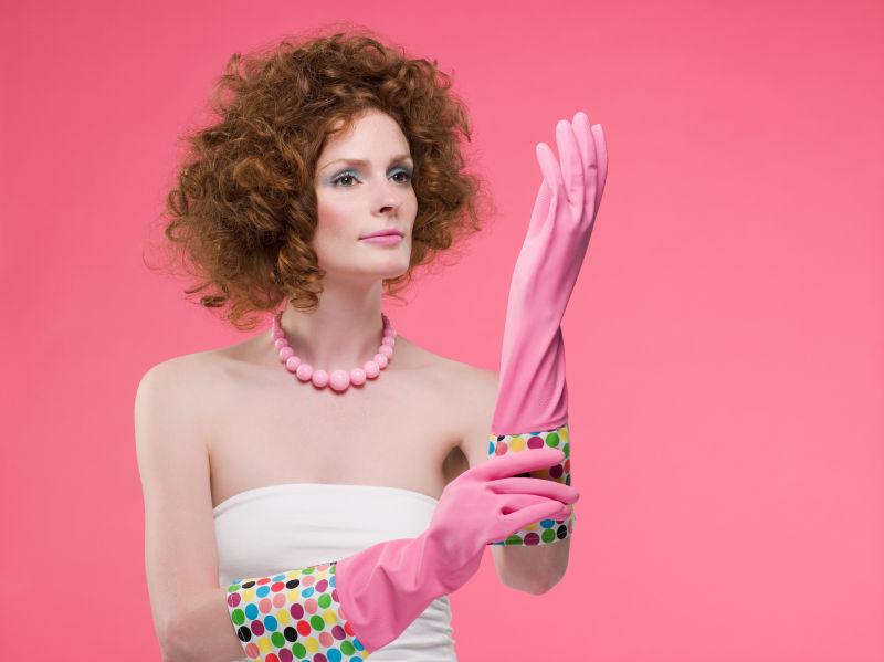 时尚的美女在带着粉色手套