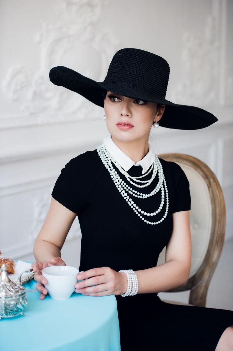 戴黑色帽子和穿着黑色礼服的优雅女士