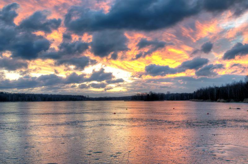 日落时有火烧云的背景下结冰的湖面