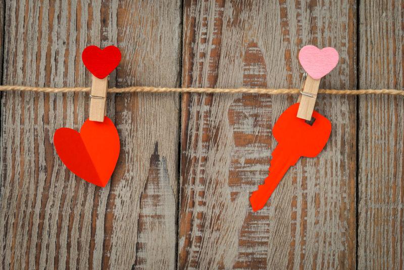 木头背景上的红纸心