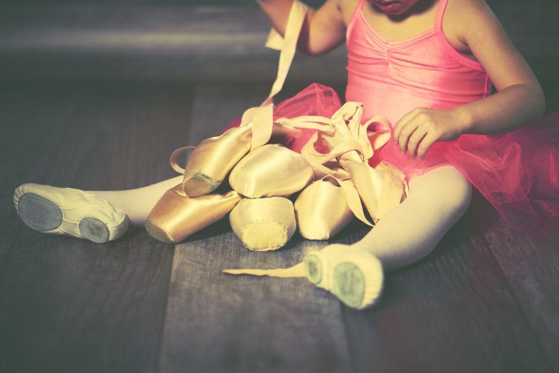 正在整理舞蹈鞋的小女孩