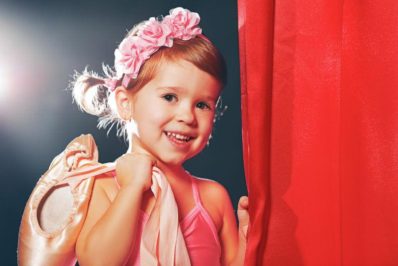 穿着舞蹈服拿着鞋子的小女孩