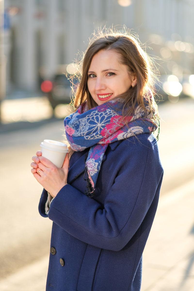 美女在冬天的街头捧着咖啡