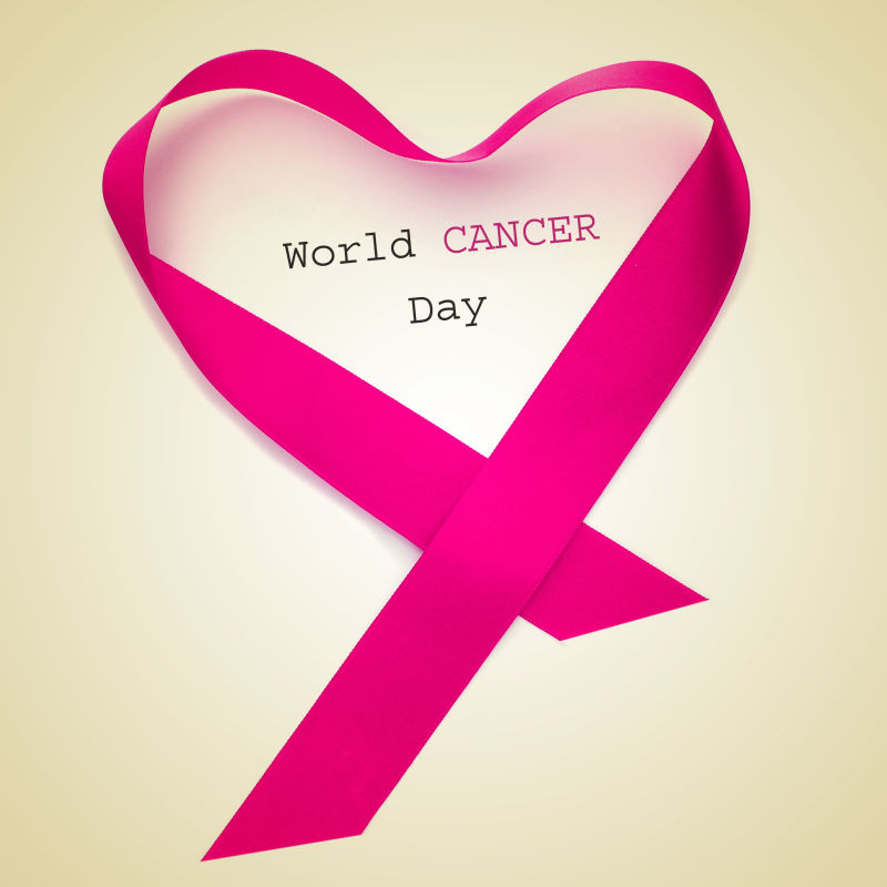 世界癌症日和粉红丝带在米色背景下形成一颗心