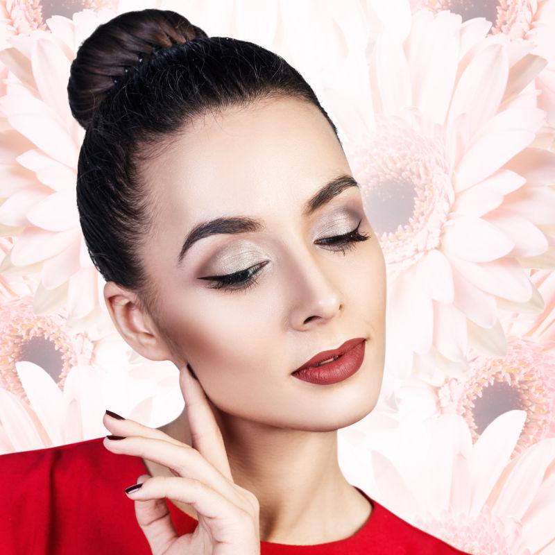 粉色菊花花朵背景下穿着红衣的美女