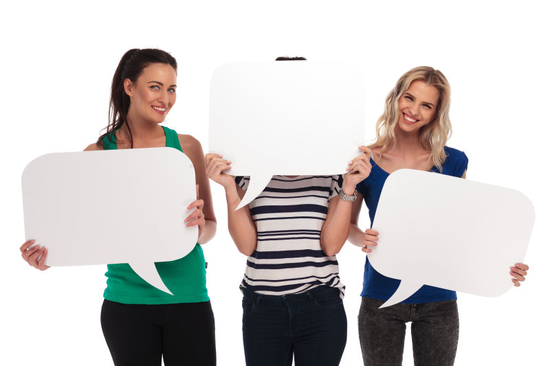 白色背景上拿着空白气泡对话框的三个美女