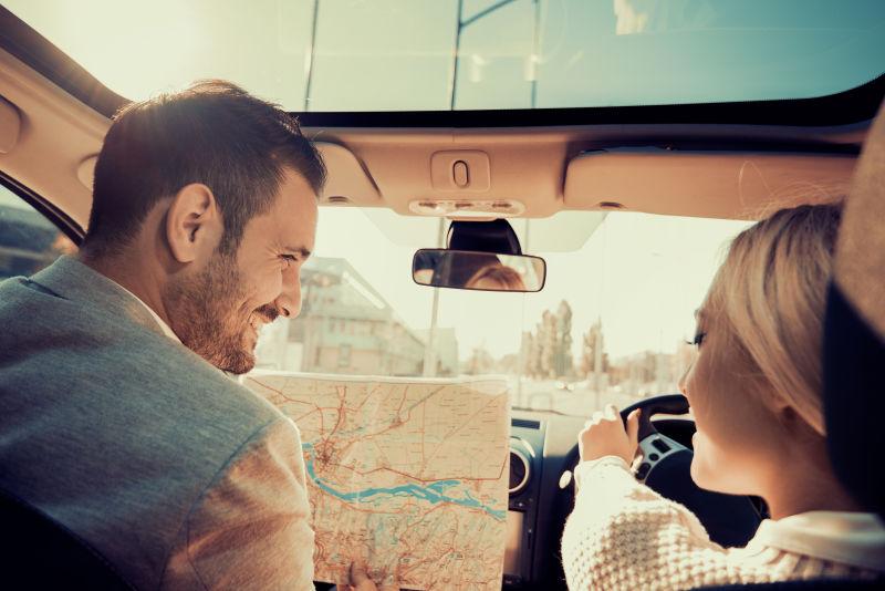 在旅途中使用地图的微笑的男人和女人