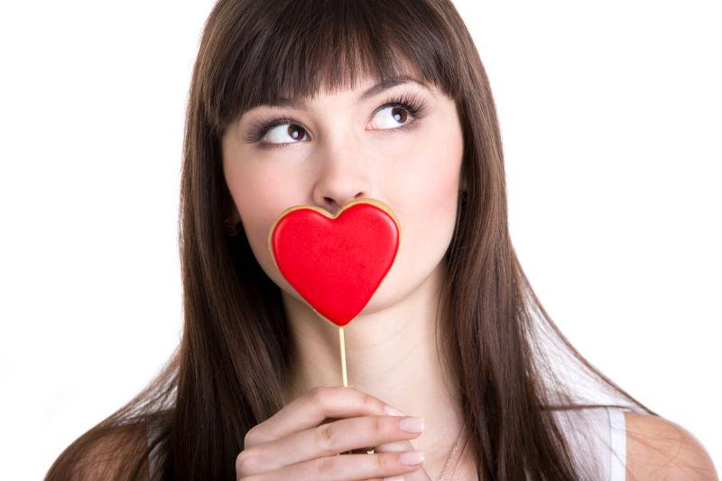 恋爱中的幸福女人拿着心形饼干