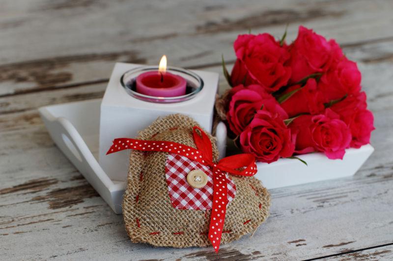 木制桌面上的托盘红玫瑰和蜡烛