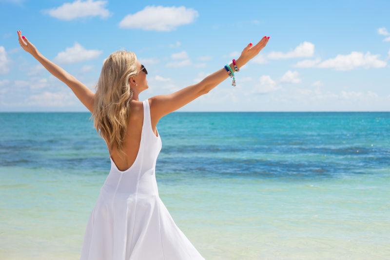 站在海边张开双手的漂亮女孩