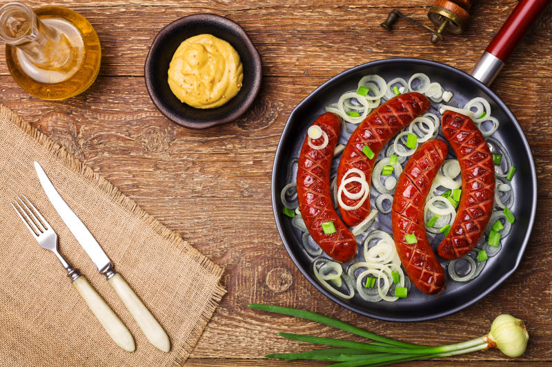 煎锅里的美味香肠和洋葱