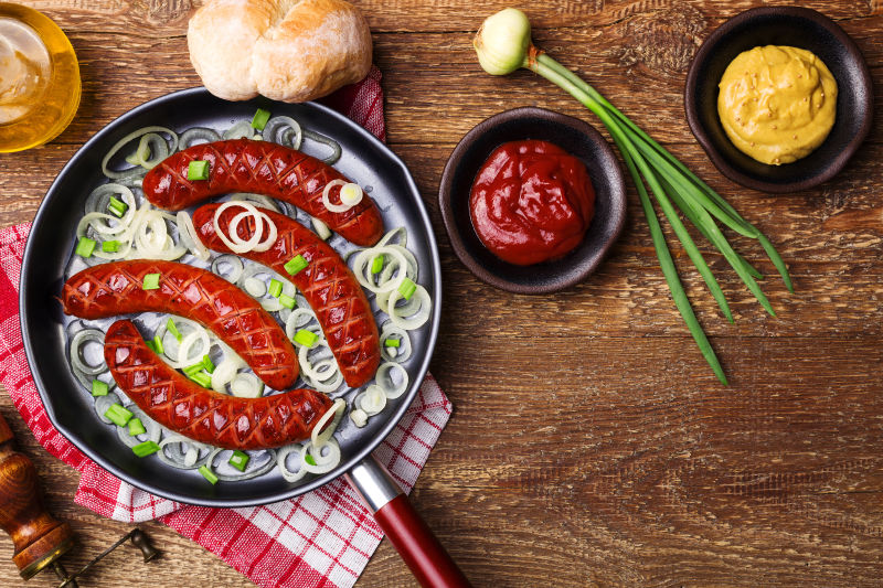 桌子上的香肠和洋葱番茄酱