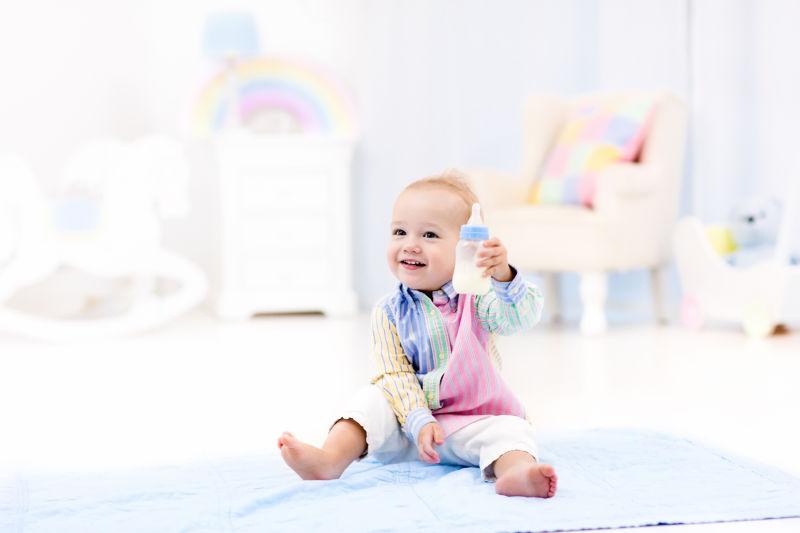 小男孩从一个瓶子里喝牛奶