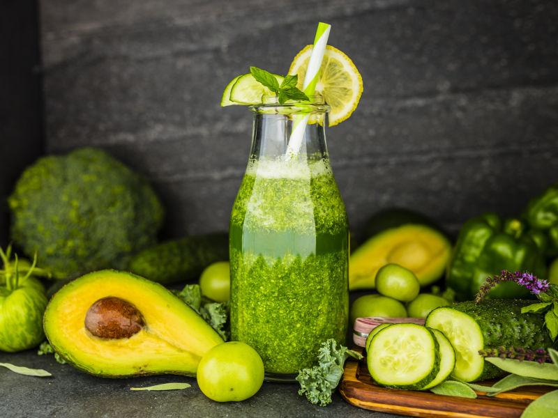 桌上的瓜果蔬菜和玻璃杯里的冰沙