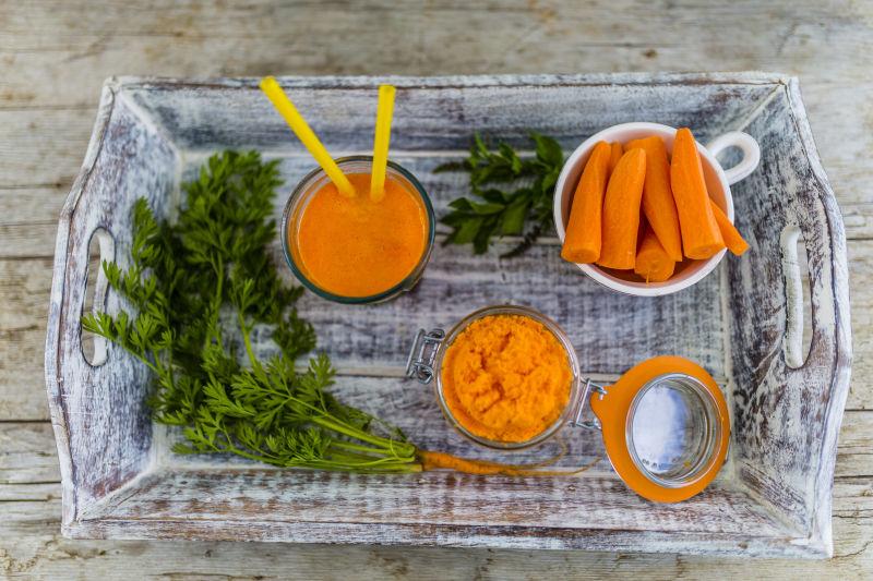 桌上的新鲜胡萝卜和胡萝卜汁