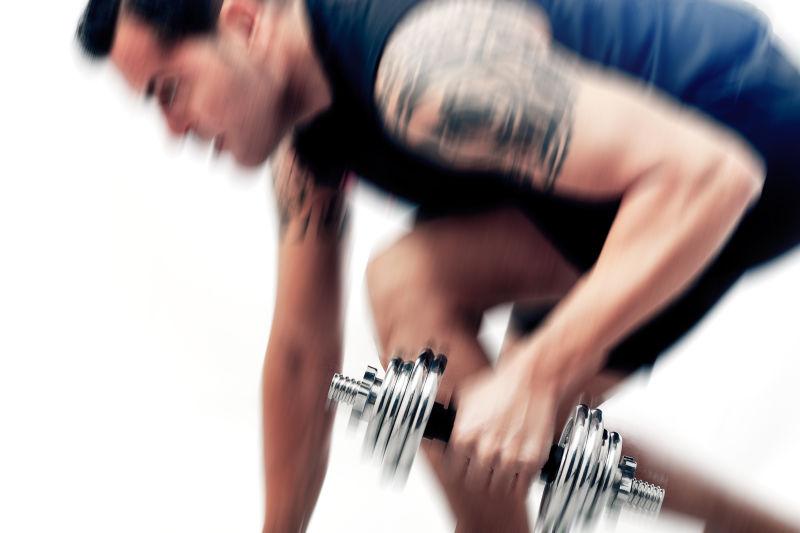 强壮的男人拿着哑铃锻炼身体