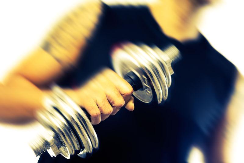 强壮的男人拿着哑铃锻炼