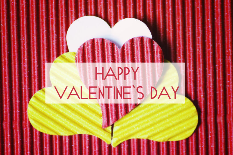 红色条纹背景下的彩色心形纸片和情人节祝福语