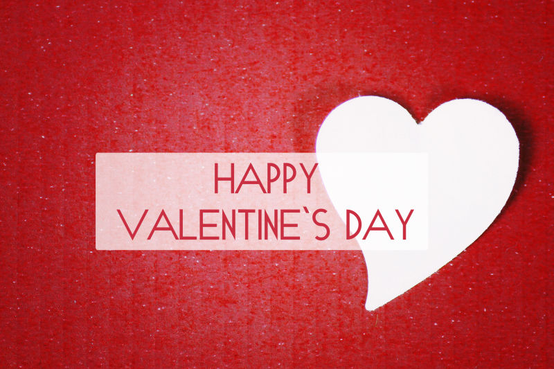 红色背景上的白色心形纸片和情人节祝福语