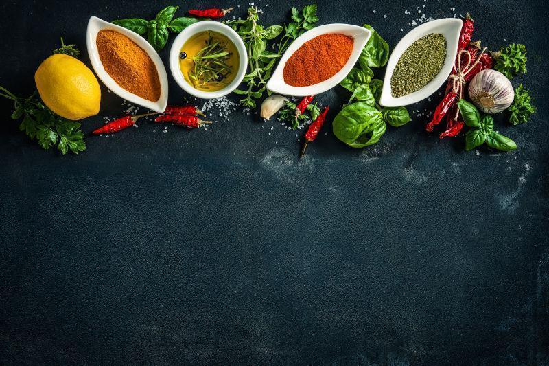 黑石背景上的烹饪调料和柠檬