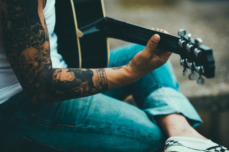 纹身男在弹奏吉他