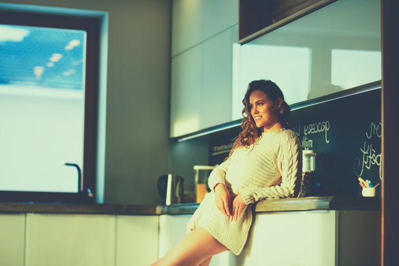 年轻的女孩在厨房微笑的站着