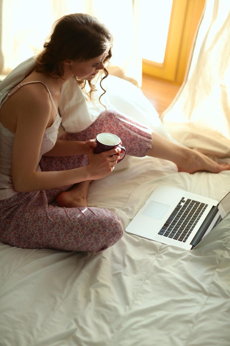 美女在床上看笔记本