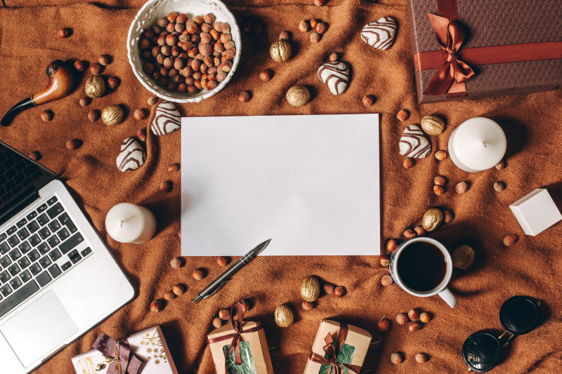 棕色布料上的笔记本电脑礼品咖啡坚果白色蜡烛