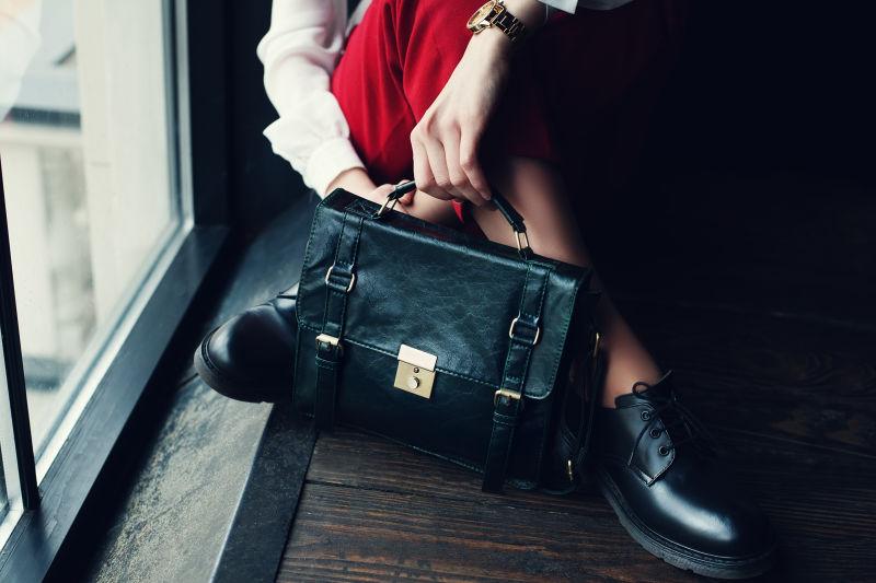 坐在飘窗上穿着红色裤子拎着黑色包包的美女腿部