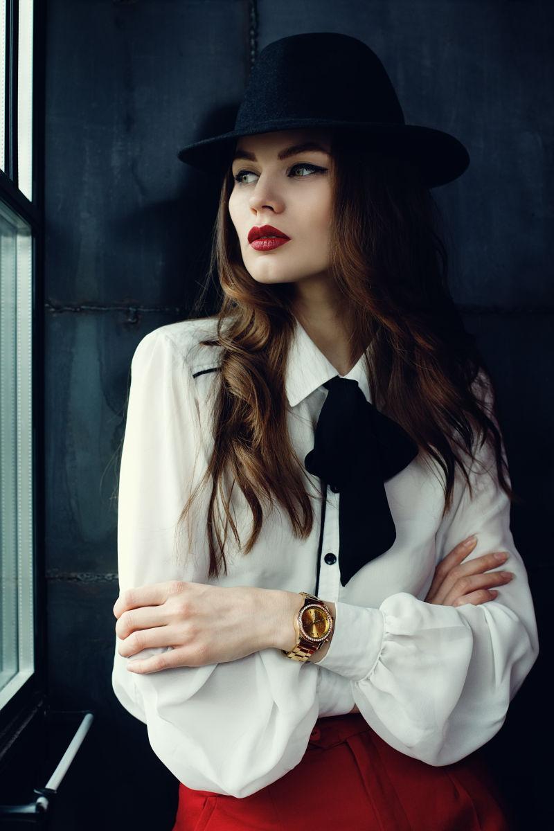 站在票窗边穿着红色裤子白色上衣的美女