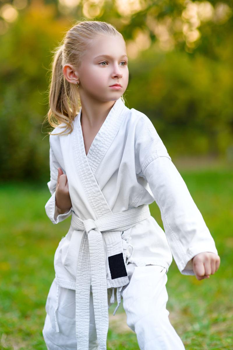 穿着白色和服的女孩在户外训练空手道练习