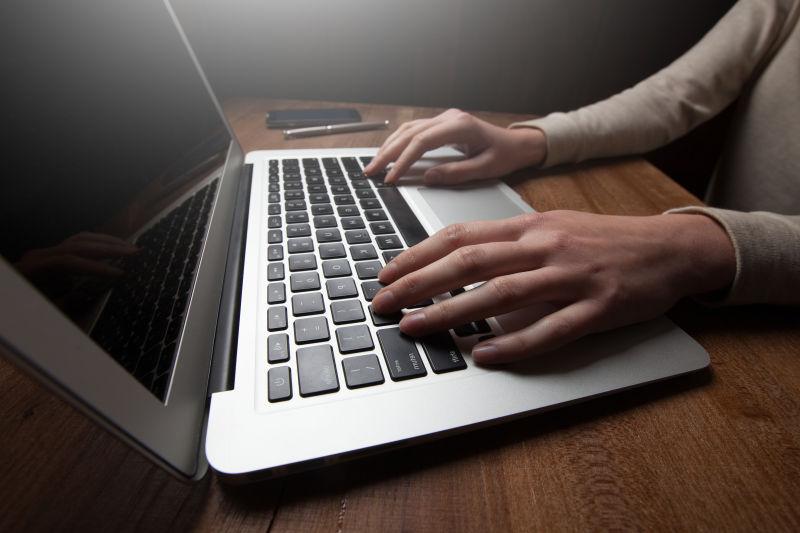 黑暗的空间中木桌上的笔记本电脑