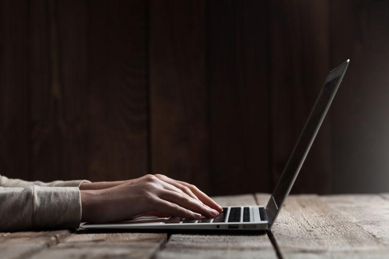 黑暗的空间中女职员在办公桌上使用笔记本电脑