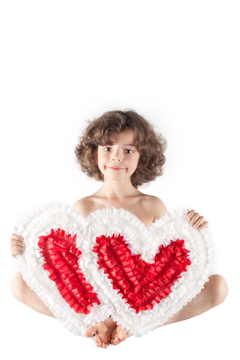 可爱的天使抱着两颗心微笑着看着相机