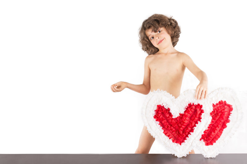 年轻的卷曲天使手里拿着两颗心