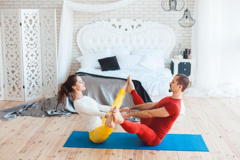 瑜伽垫上一对练习瑜伽的夫妇