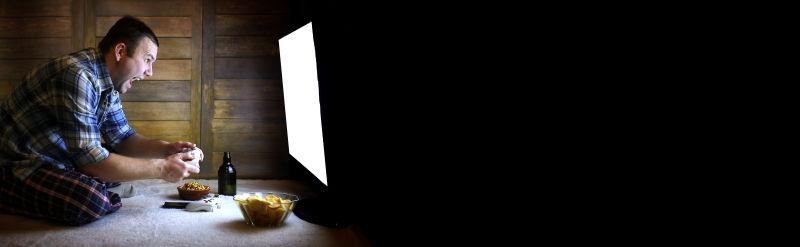 空白电视屏幕前玩游戏的激动男人