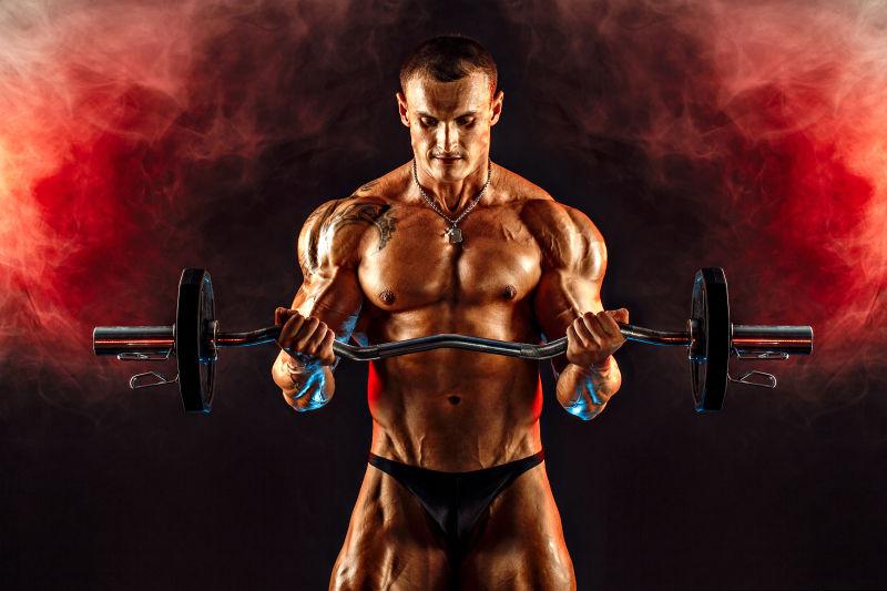 肌肉发达的男人在红色烟雾中举起哑铃