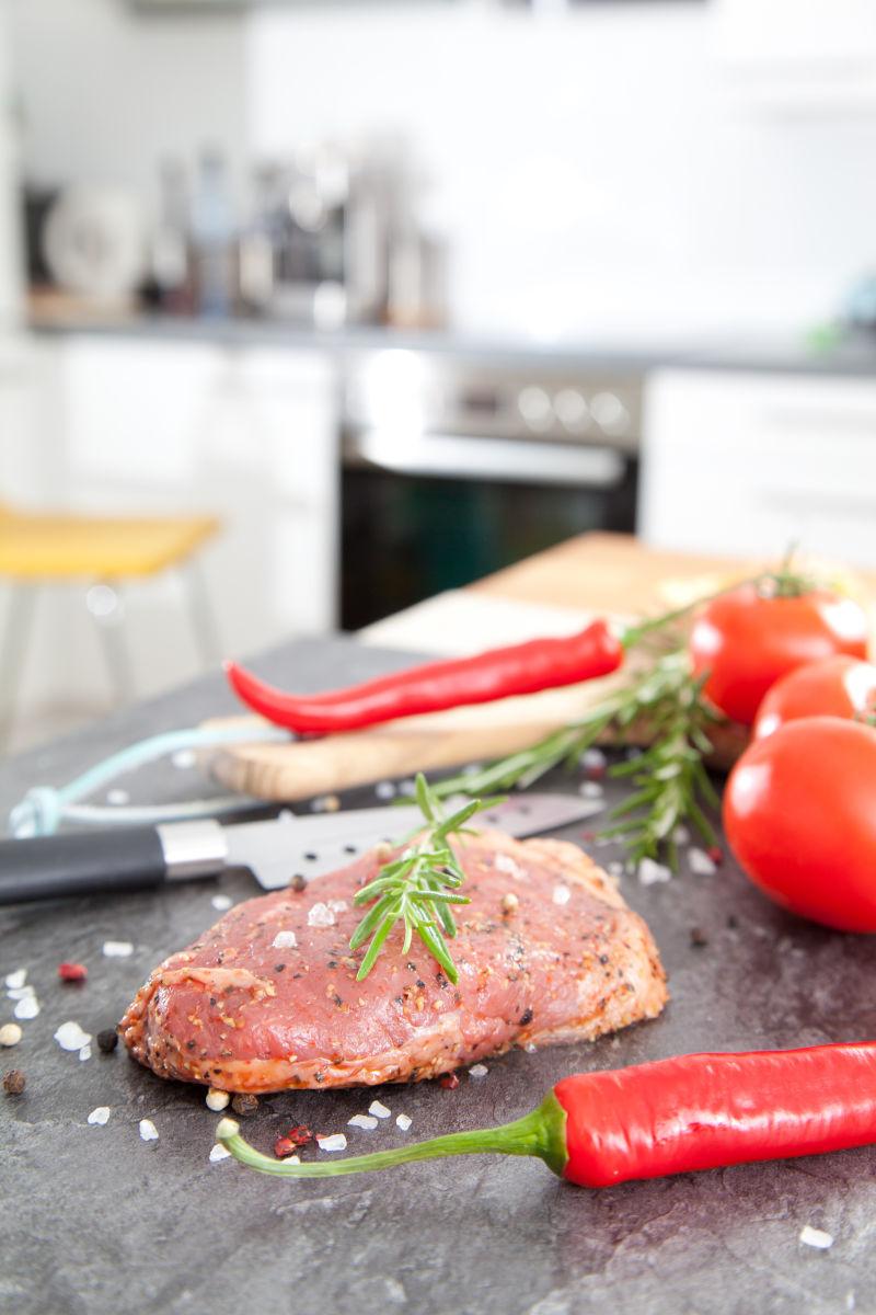 厨房背景中牛排制作食材