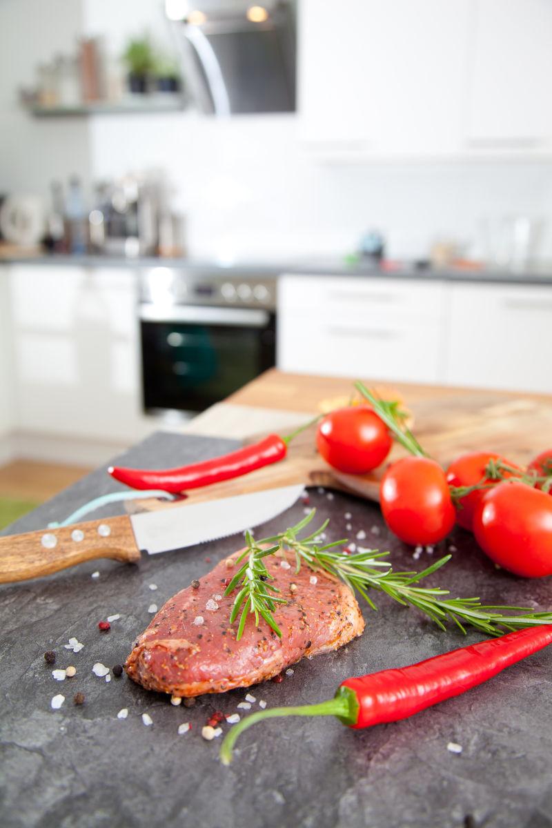 厨房背景中制作牛排配料