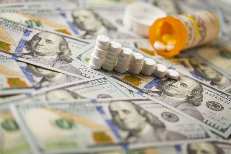 美元钞票上的药瓶和排列整齐的药片