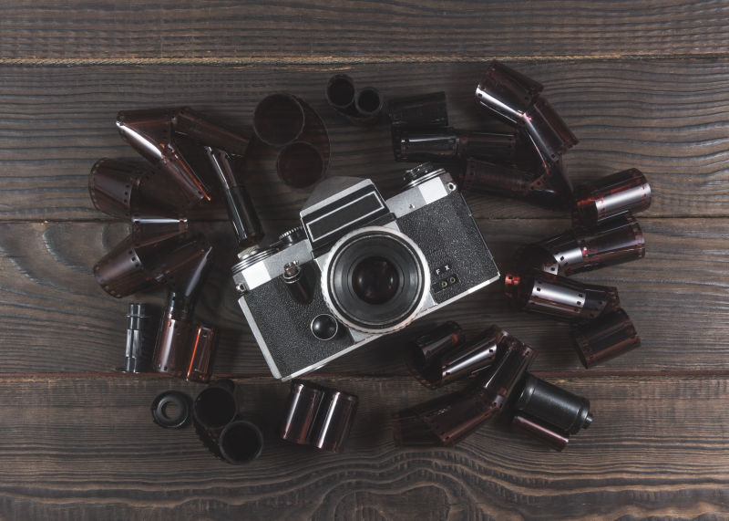 旧木桌上的复古相机和胶片