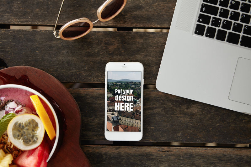 木桌上的水果太阳镜手机和笔记本电脑