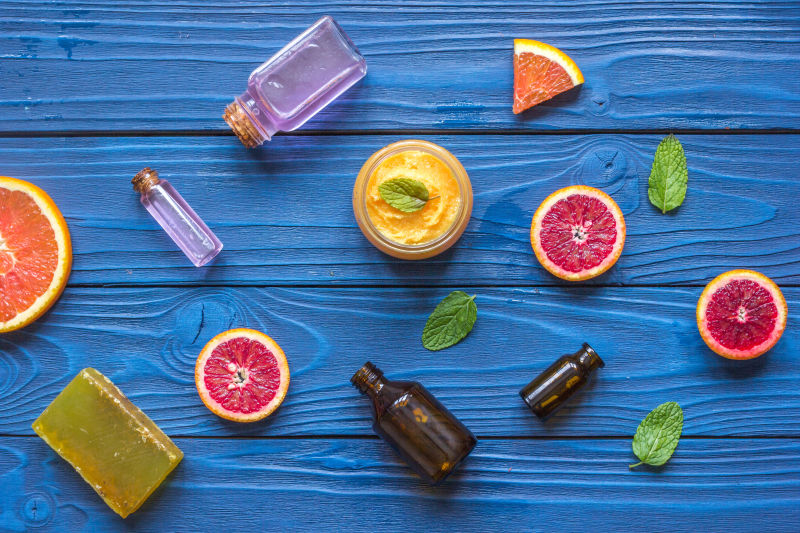 蓝色木桌上的柑橘和化妆品