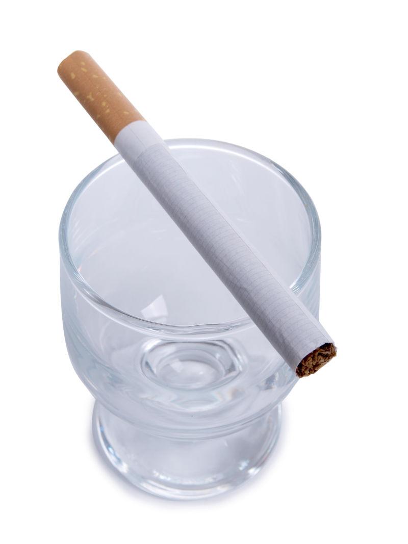 白色背景下的香烟以及酒杯