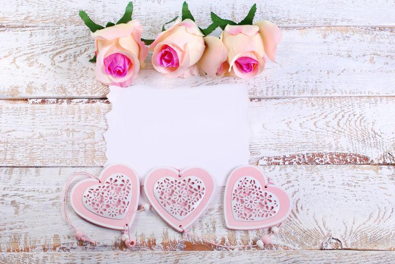 空白的卡片和玫瑰在白色木板上