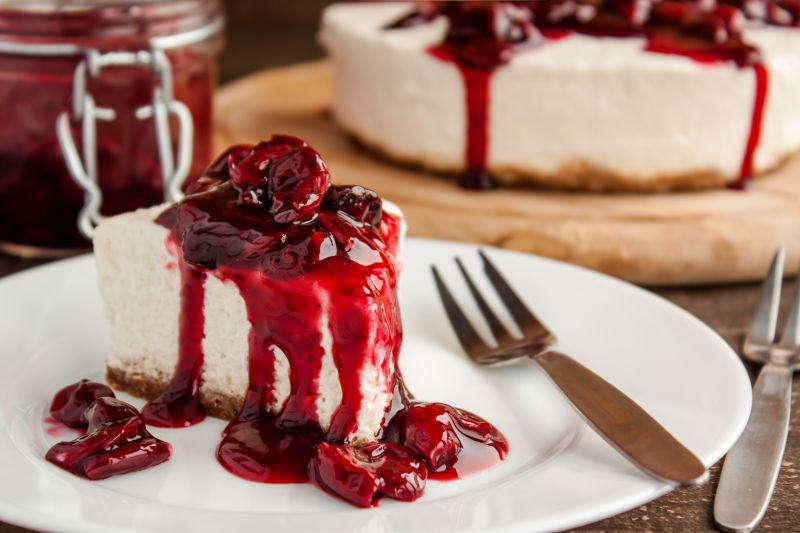 樱桃芝士蛋糕和叉子在白色盘里